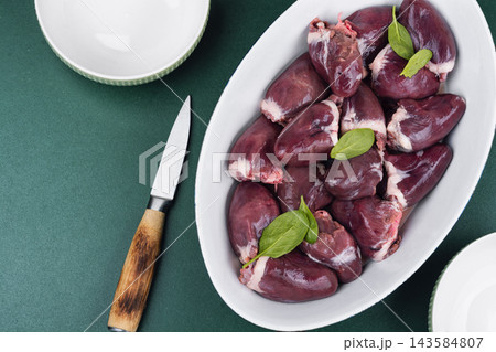 Raw turkey offal in baking dish with herbs and spices 143584807