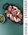 Raw turkey hearts with onion and herbs in baking dish 143584808