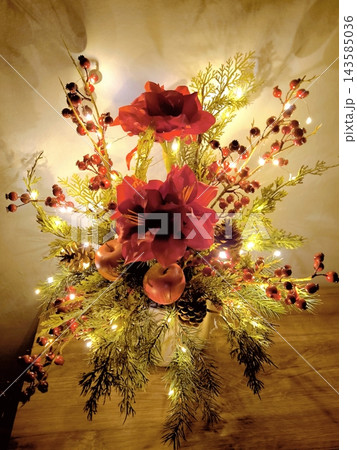 Christmas floral arrangement with red flowers, berries and lights 143585036