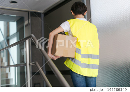 マンションに配達をする女性 143586349