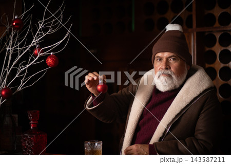 Elegant Santa holding red Christmas ornament at bar 143587211