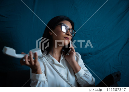 Young woman multitasking with modern and vintage phone 143587247