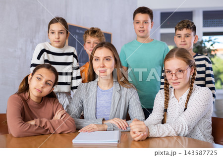 Group photo of teacher and preteen schoolchildren in classroom Group photo of teacher and preteen schoolchildren in classroom 143587725
