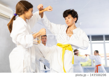 Young pupils train to perform defensive karate installations and attacking combat techniques Young pupils train to perform defensive karate installations and attacking combat techniques 143588206