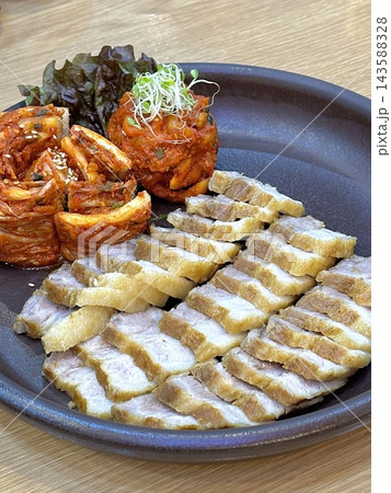 Suyuk, a traditional Korean dish of boiled pork slices, tender and juicy, often served with salted shrimp sauce, garlic, and ssamjang. Perfect for wrapping in lettuce for a flavorful, balanced bite. Suyuk, a traditional Korean dish of boiled pork slices, tender and juicy, often served with salted shrimp sauce, garlic, and ssamjang. Perfect for wrapping in lettuce for a flavorful, balanced bite. 143588328