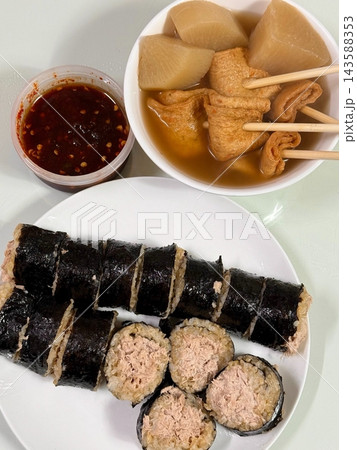 Delicious kimbap rolls filled with seasoned rice and fresh ingredients, paired with warm and savory odeng skewers in flavorful broth. A perfect Korean street food combination for a satisfying meal! 143588353