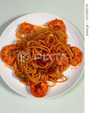 Classic spaghetti coated in rich tomato sauce, offering a simple yet delicious combination of tangy, savory flavors perfect for a comforting meal. 143588354