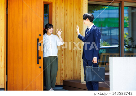 出勤する夫を玄関で見送る妻 出勤する夫を玄関で見送る妻 143588742