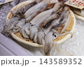 氷の上に並べて販売される新鮮なイカ 143589352