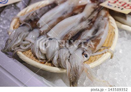 氷の上に並べて販売される新鮮なイカ 143589352