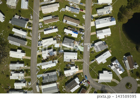 Severely damaged by hurricane Ian houses in Florida mobile home residential area. Consequences of natural disaster 143589395