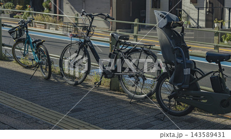 歩道脇に並んで駐輪された自転車と子乗せ自転車 143589431