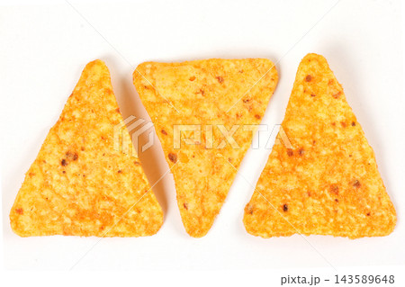 Three crispy baked triangular nacho tortilla chips isolated on a white background. Mexican cuisine. Three crispy baked triangular nacho tortilla chips isolated on a white background. Mexican cuisine. 143589648
