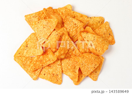 Portion of seasoned, crispy, triangular corn nachos, isolated on a white background. Mexican cuisine. Portion of seasoned, crispy, triangular corn nachos, isolated on a white background. Mexican cuisine. 143589649