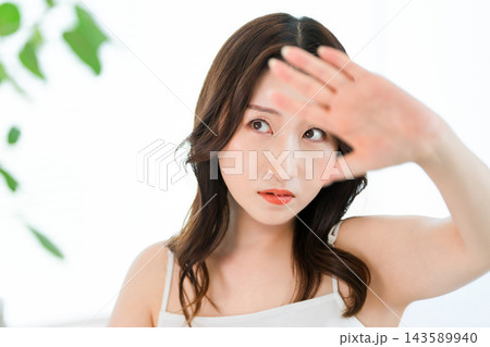 強い日差しを手で遮る40代・50代の女性。紫外線や日焼けを気にする美容イメージ 強い日差しを手で遮る40代・50代の女性。紫外線や日焼けを気にする美容イメージ 143589940