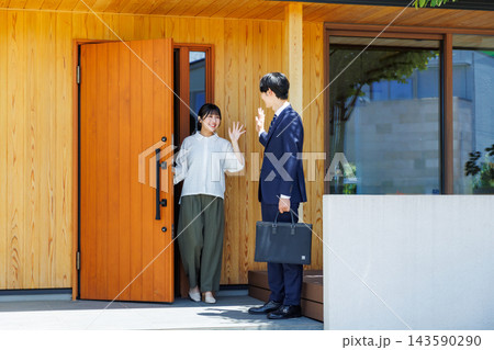 出勤する夫を玄関で見送る妻 出勤する夫を玄関で見送る妻 143590290