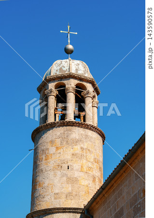 View of a stone church tower against a blue sky during the daytime View of a stone church tower against a blue sky during the daytime 143590578