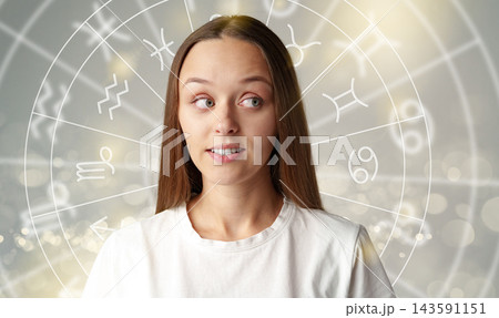 Astrology zodiac signs with a young woman in front of astrological symbols and a glowing background Astrology zodiac signs with a young woman in front of astrological symbols and a glowing background 143591151