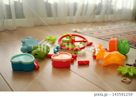 Colorful plastic toys scattered on the floor in a living room 143591250