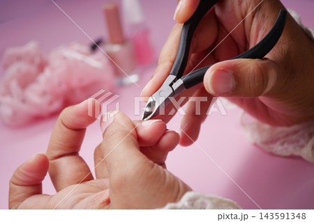 Nail care session with tools and products on a pink background Nail care session with tools and products on a pink background 143591348