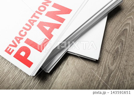 Emergency 911 evacuation plan document on wooden surface for safety preparation and response Emergency 911 evacuation plan document on wooden surface for safety preparation and response 143591651