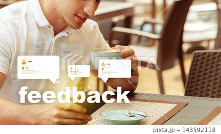 Man sitting in a cafe drinking coffee while looking at feedback on his device 143592118