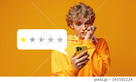 Young person looks worried while checking phone with low star rating on review 143592224