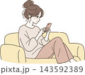 ソファでくつろぎながらスマートフォンを見る女性 143592389