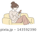 ソファでくつろぎながらスマートフォンを見る女性 143592390