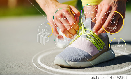 Person tying shoelaces while tracking running metrics such as speed, distance, and heart rate Person tying shoelaces while tracking running metrics such as speed, distance, and heart rate 143592391