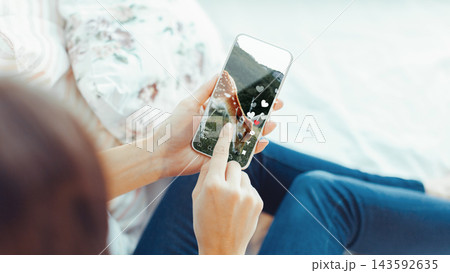 Using a smartphone to interact with social media chats and calls while sitting comfortably Using a smartphone to interact with social media chats and calls while sitting comfortably 143592635