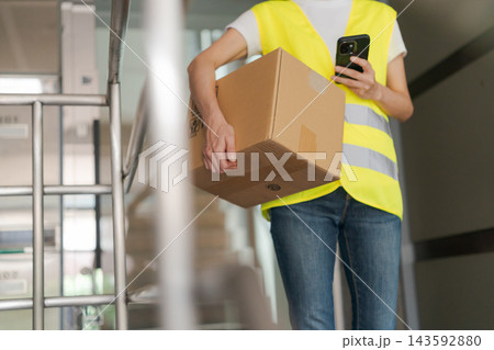 マンションに配達をする女性 143592880