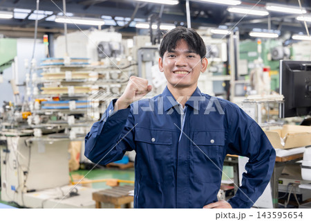 製造工場で笑顔でガッツポーズをする若い外国人労働者・日本の製造業で活躍する外国人材 製造工場で笑顔でガッツポーズをする若い外国人労働者・日本の製造業で活躍する外国人材 143595654
