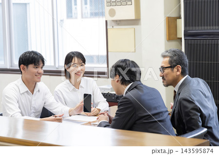 スマートフォンの通訳アプリを使いながら日本の仲介業者スタッフと就労手続きや申請書類を確認する外国人労 143595874