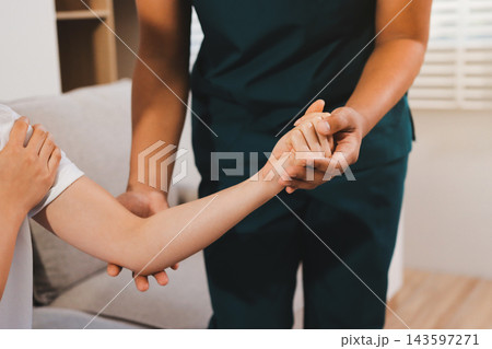 Selective focus of smiling patient sitting on couch and chiropractor examining patient shoulder in massage cabinet at clinic Selective focus of smiling patient sitting on couch and chiropractor examining patient shoulder in massage cabinet at clinic 143597271