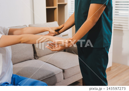Healthcare professional assisting patient with arm exercise Healthcare professional assisting patient with arm exercise 143597273