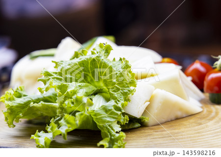 cheese and lettuce on wooden plate cheese and lettuce on wooden plate 143598216