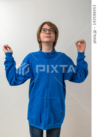 Young person wearing a blue fleece jacket and glasses, standing against a white background, looking up with an expression of hope and outstretched hands, symbolizing wonder and aspiration Young person wearing a blue fleece jacket and glasses, standing against a white background, looking up with an expression of hope and outstretched hands, symbolizing wonder and aspiration 143598453