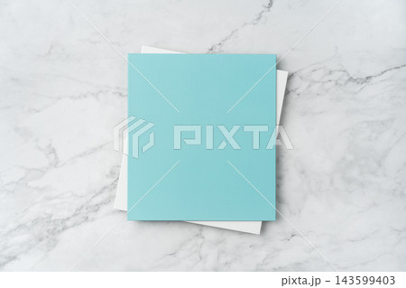 Top view of blank blue and white square greeting card mockup on marble background with copy space Top view of blank blue and white square greeting card mockup on marble background with copy space 143599403