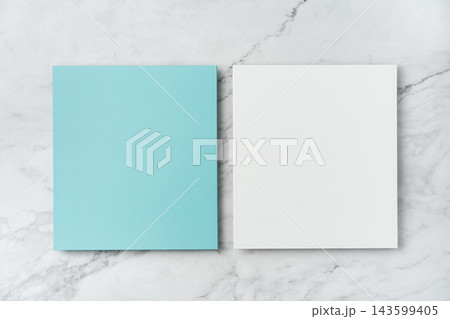 Top view of blank blue and white square greeting card mockup on marble background with copy space Top view of blank blue and white square greeting card mockup on marble background with copy space 143599405