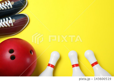 Bowling ball, shoes and pins on yellow background, flat lay. Space for text 143600519