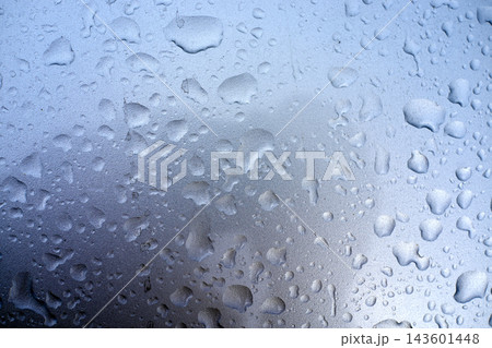 Raindrops on glass window with blurred city lights Raindrops on glass window with blurred city lights 143601448