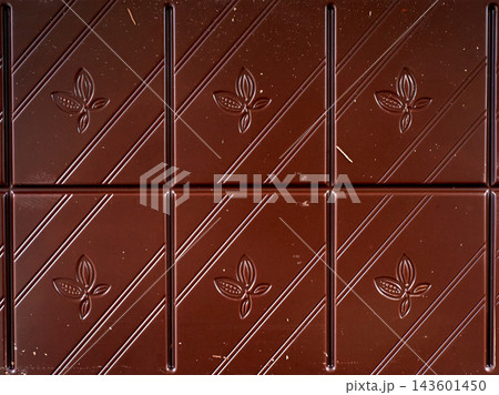 Brown chocolate bar texture with embossed flower pattern 143601450