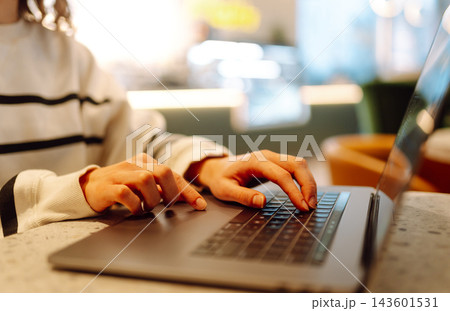 Close-up of hands working on a laptop keyboard. Young woman using laptop computer. Freelance Close-up of hands working on a laptop keyboard. Young woman using laptop computer. Freelance 143601531