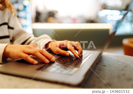 Close-up of hands working on a laptop keyboard. Young woman using laptop computer. Freelance Close-up of hands working on a laptop keyboard. Young woman using laptop computer. Freelance 143601532