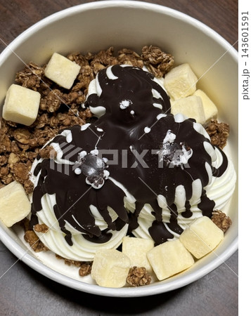 Swirled yogurt ice cream dessert served in a cup, smooth creamy texture with glossy surface, topped with fresh fruit pieces, highlighting its refreshing and inviting appearance in detail Swirled yogurt ice cream dessert served in a cup, smooth creamy texture with glossy surface, topped with fresh fruit pieces, highlighting its refreshing and inviting appearance in detail 143601591