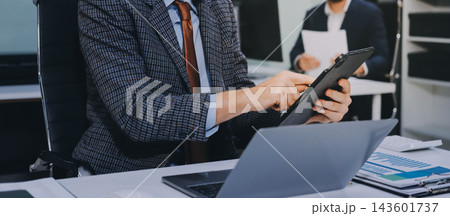 Business team collaborating on digital data analysis in modern office 143601737