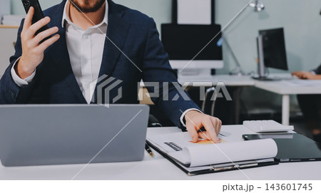Two partners, team of professional business people working, discussing, writing notes at desk. Mature focused senior mentor leader man showing young woman manager project on laptop in modern office 143601745