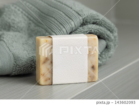 Beige soap mockup with blank label near towel in sage green bathroom, unbranded packaging Beige soap mockup with blank label near towel in sage green bathroom, unbranded packaging 143602093