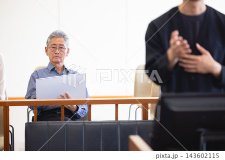 法廷の傍聴席で裁判の様子を記録する男性の法廷画家 143602115